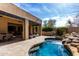 Inviting backyard pool with rock waterfall and a stone patio, and a beautiful seamless transition to the indoors at 27708 N 110Th Pl, Scottsdale, AZ 85262