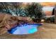 Outdoor living space featuring a pool with waterfall and fireplace with seating at 27708 N 110Th Pl, Scottsdale, AZ 85262