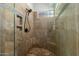 This bathroom showcases the walk-in shower, with unique tile, glass door, and a rainfall shower head at 27708 N 110Th Pl, Scottsdale, AZ 85262