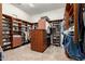 Organized walk-in closet with custom wood shelving, drawers, and ample storage space for clothes and accessories at 27708 N 110Th Pl, Scottsdale, AZ 85262