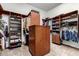 A well organized walk-in closet featuring wood shelving, drawers, and ample storage space at 27708 N 110Th Pl, Scottsdale, AZ 85262