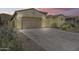 Exterior view of home featuring desert landscaping and brick paver driveway leading to garage at 32366 N 133Rd Ln, Peoria, AZ 85383