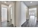 The bright hallway with gray tile floors leads to bedrooms, kitchen, and living spaces at 32366 N 133Rd Ln, Peoria, AZ 85383