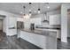 A modern kitchen featuring a spacious center island, stainless steel appliances, and white cabinets at 32366 N 133Rd Ln, Peoria, AZ 85383