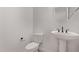 Powder room features a modern white pedestal sink and toilet at 40499 W Michaels Dr, Maricopa, AZ 85138