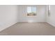 Bright bedroom features plush carpeting and a large window offering neighborhood views at 40499 W Michaels Dr, Maricopa, AZ 85138