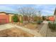 Backyard featuring a covered patio, lush desert landscaping, and a paved walkway at 42266 W Sparks Dr, Maricopa, AZ 85138