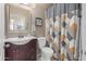 Neutral bathroom featuring a classic vanity, toilet, and patterned shower curtain adding a touch of style at 42266 W Sparks Dr, Maricopa, AZ 85138