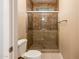 Bathroom with a shower, toilet, tile walls and floor, and glass block window at 5303 N 7Th St # 109, Phoenix, AZ 85014