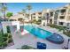 Resort-style community pool with lounge seating, tables, umbrellas, and a charming water feature at 5303 N 7Th St # 109, Phoenix, AZ 85014