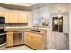 Modern kitchen with stainless appliances, stone countertops, and bar seating open to living area at 5303 N 7Th St # 109, Phoenix, AZ 85014