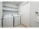 Convenient laundry room with modern washer, dryer, and built-in shelving for storage at 5303 N 7Th St # 109, Phoenix, AZ 85014
