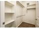 Spacious walk-in closet with wood floor and white shelves and hanging rods at 5303 N 7Th St # 109, Phoenix, AZ 85014