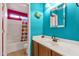 Colorful bathroom features turquoise walls, white vanity, and shower/tub combination at 5415 E Mckellips Rd # 24, Mesa, AZ 85215