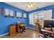 Bright bedroom with blue walls, three windows, ceiling fan, and a computer desk setup at 5415 E Mckellips Rd # 24, Mesa, AZ 85215