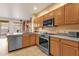 Bright kitchen featuring stainless steel dishwasher, range, and wood cabinets, and backyard access at 5415 E Mckellips Rd # 24, Mesa, AZ 85215