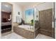A luxurious bathroom with a soaking tub surrounded by decorative tile and a glass-enclosed shower at 5810 E Calle Marita E --, Cave Creek, AZ 85331