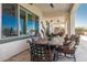 Covered patio with travertine flooring, ceiling fans, a stone table and comfortable cushioned chairs at 5810 E Calle Marita E --, Cave Creek, AZ 85331