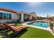 Stunning backyard oasis featuring pristine pool, manicured turf, desert landscaping, and covered patio at 5810 E Calle Marita E --, Cave Creek, AZ 85331