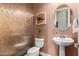 Stylish powder room features a pedestal sink, decorative mirror, and unique textured wallpaper at 5810 E Calle Marita E --, Cave Creek, AZ 85331