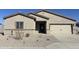A tan single-story home featuring a two-car garage and low-maintenance desert landscaping at 618 W Pintail Dr, Casa Grande, AZ 85122