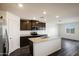 Modern kitchen features dark wood cabinets, granite countertops, stainless appliances, and an island with a sink at 618 W Pintail Dr, Casa Grande, AZ 85122