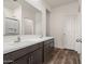 Bathroom featuring double sinks, granite countertops, dark wood cabinets, and a glass enclosed shower at 619 W Pintail Dr, Casa Grande, AZ 85122