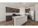 Modern kitchen with stainless steel appliances, granite countertops, a kitchen island, and dark wood cabinets at 619 W Pintail Dr, Casa Grande, AZ 85122