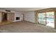 Living room with plush carpeting and a white brick fireplace, leading to the outdoor pool area through sliding glass doors at 8043 N 10Th Pl, Phoenix, AZ 85020