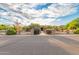 Charming stone home featuring a manicured front yard, stone pillars, and mature trees at 8260 N Buena Vista Dr, Casa Grande, AZ 85194