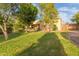 Well-manicured front yard with mature trees and lush green grass add to this home's curb appeal at 8260 N Buena Vista Dr, Casa Grande, AZ 85194