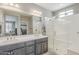 Bathroom featuring double sinks, granite countertops, and a glass-enclosed shower at 830 E Garden Basket Dr, Queen Creek, AZ 85140