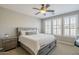 Serene bedroom with neutral colors, a ceiling fan, and plantation shutters for natural light at 830 E Garden Basket Dr, Queen Creek, AZ 85140