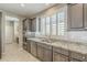 Modern kitchen with stainless steel appliances, gray cabinets, granite countertops, and a double sink at 830 E Garden Basket Dr, Queen Creek, AZ 85140