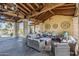 Inviting covered outdoor patio with stone pillars and comfortable seating arrangement for relaxation at 830 E Garden Basket Dr, Queen Creek, AZ 85140