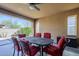 Covered patio featuring a dining table with six chairs with red cushions and an outdoor view at 830 E Garden Basket Dr, Queen Creek, AZ 85140