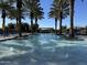 Beautiful community pool area with palm trees, lounge seating, and fountains at 830 E Garden Basket Dr, Queen Creek, AZ 85140
