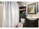 Compact bathroom featuring a shower with patterned curtain and a vanity with ample storage, maximizing space at 8520 E Laguna Azul Ave, Mesa, AZ 85209