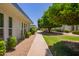 A serene exterior view of the property showcasing a lush green lawn at 10859 W Coggins Dr, Sun City, AZ 85351