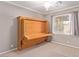 Cozy bedroom featuring a murphy bed, ceiling fan and natural light at 10918 E Oro Ave, Mesa, AZ 85212