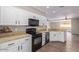 Well-lit kitchen features granite counters, modern appliances, and white cabinets at 10918 E Oro Ave, Mesa, AZ 85212
