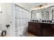 Well-lit bathroom features a large vanity with a mirror, and a shower with modern patterned shower curtain at 11341 W Barbara Ave, Peoria, AZ 85345