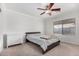 Cozy bedroom features a ceiling fan, a comfortable bed and a large window for natural lighting at 11341 W Barbara Ave, Peoria, AZ 85345