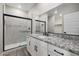 Modern bathroom featuring granite countertops, white cabinets, and a glass walk-in shower with black hardware at 11522 W Deanne Dr, Youngtown, AZ 85363