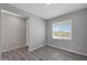 Well-lit bedroom with wood-look flooring, neutral paint, and a large window at 11522 W Deanne Dr, Youngtown, AZ 85363