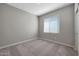 Bedroom with neutral carpet, light gray walls, white trim, and a window for plenty of natural light at 11522 W Deanne Dr, Youngtown, AZ 85363