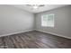 Bedroom with light grey walls, white trim, wood-look flooring, and a large window to let in natural light at 11522 W Deanne Dr, Youngtown, AZ 85363