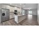 Modern kitchen featuring stainless steel appliances, an island, and views into the living area at 11522 W Deanne Dr, Youngtown, AZ 85363