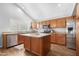 Spacious kitchen with wood cabinets, a kitchen island, stainless steel appliances, and lots of natural light at 1225 E Sea Gull Dr, Gilbert, AZ 85234