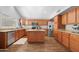 Open kitchen features stainless steel appliances, wood cabinets, granite countertops, and a breakfast bar island at 1225 E Sea Gull Dr, Gilbert, AZ 85234